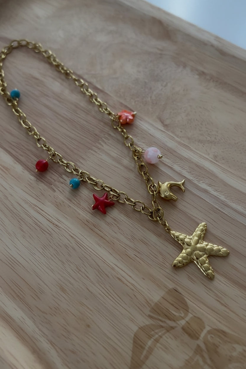 Collier bohème doré étoile de mer et dauphin / détail - Aleca Jewelry